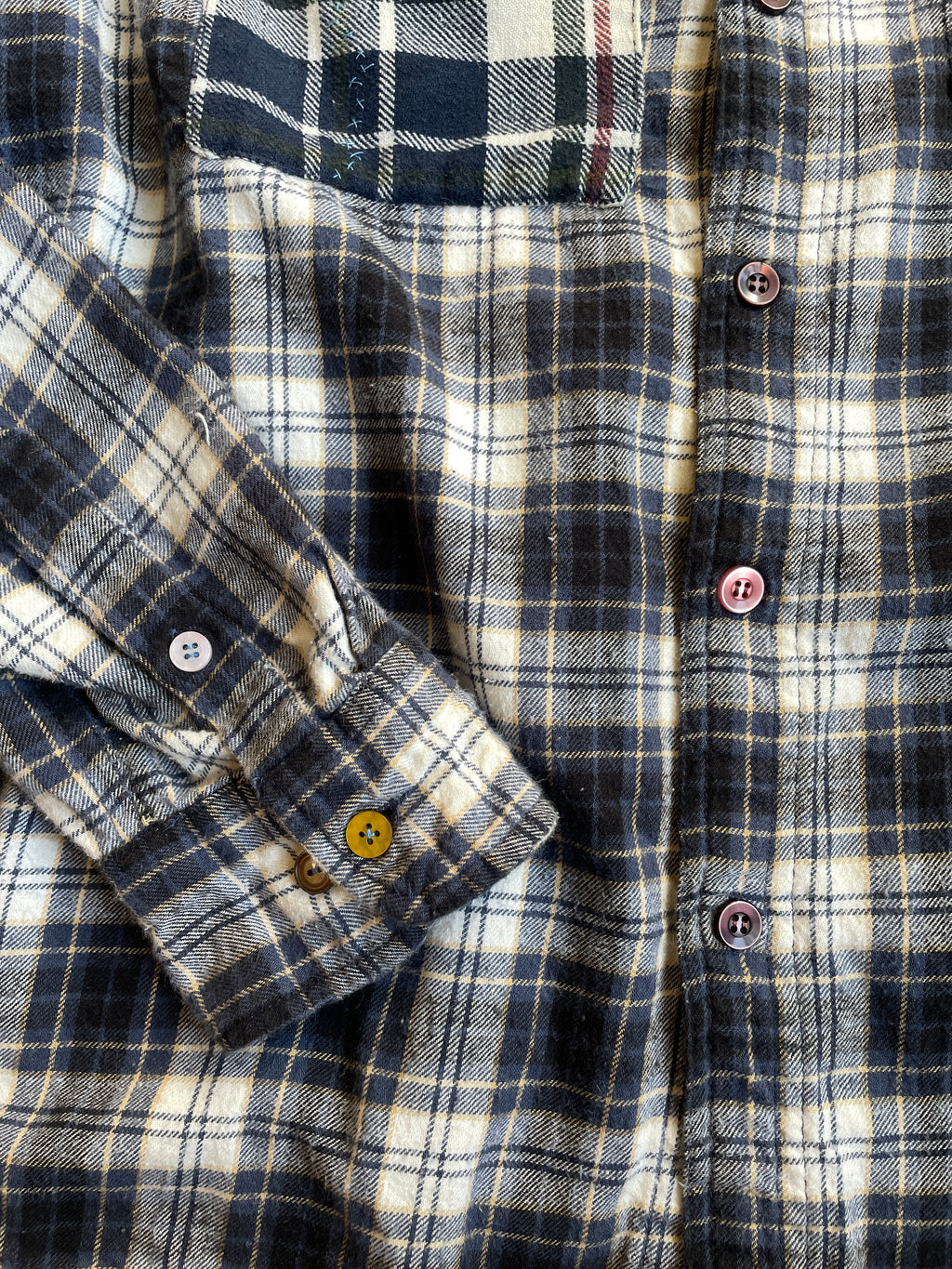 Close-up of a plaid shirt with mismatched buttons 