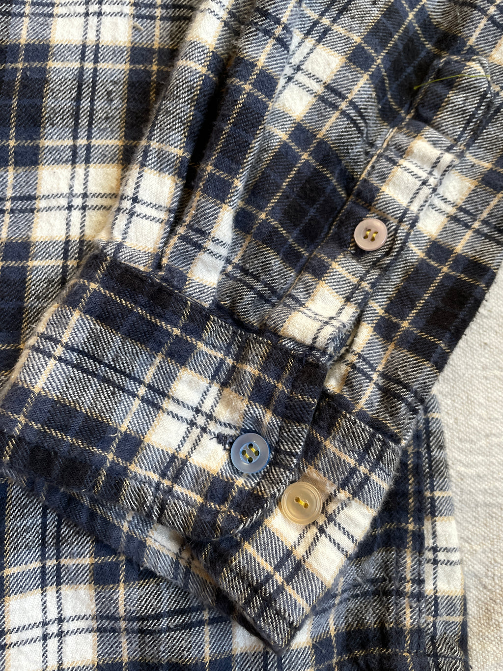 Close-up of a plaid shirt with mismatched buttons